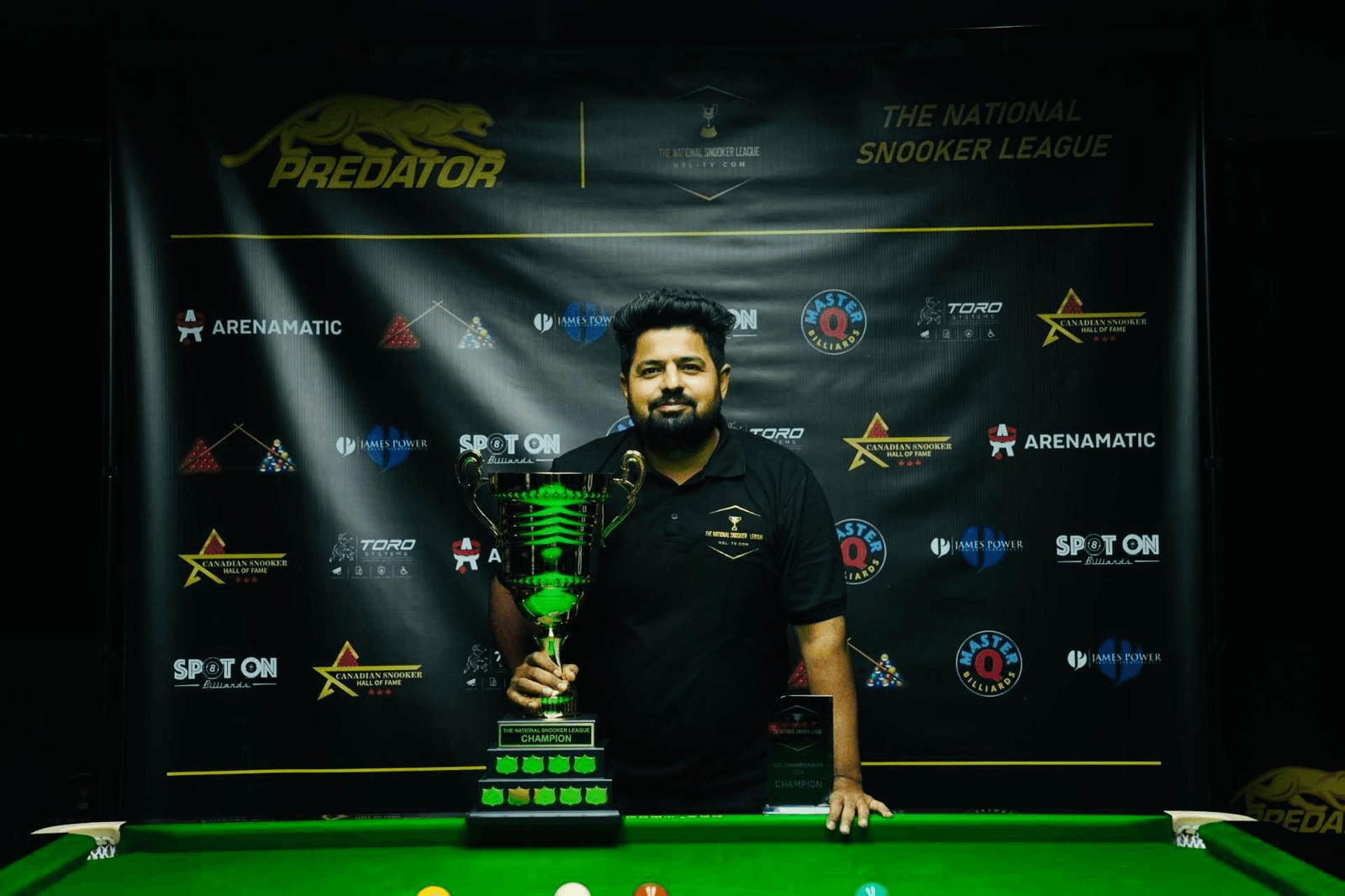 The lead mentor holding a snooker championship trophy